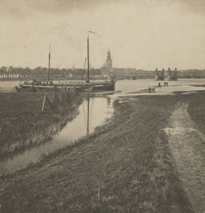 F000096 Een zeil-vrachtschip bevaart de IJssel, op de achtergrond het aanzicht van de stad met de Nieuwe Toren en de ...