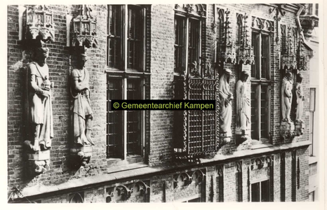 F001367 Beelden en laat-gotische ijzeren kooi aan de gevel van het Oude Raadhuis aan de Oudestraat, v.l.n.r. Karel de ...