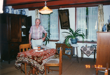 F013492 De bewoner Gerrit Jan Bos in de woonkamer van het boerderijtje (gemeentelijk monument) aan de Dorpsweg nr. 91 ...