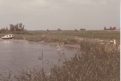 F015760 zonnende badgasten op een weiland aan de IJssel(?).