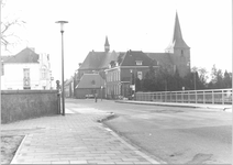72 Vanaf de brug (streeperstraat) richting Hoofdstraat met rechts de Rooms Katholieke Petrus en Paulus Kerk en links ...