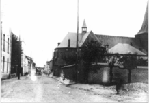 76 De Hoofdstraat met rechts de Rooms Katholieke Petrus en Pauluskerk en links beneden het Groene Kruis en boven een ...