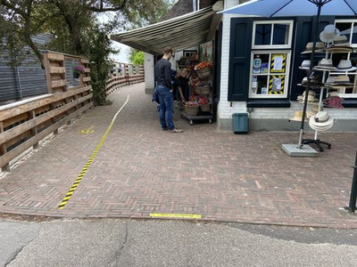 30 Een souvenirwinkel aan het Binnenpad in Giethoorn, de looproute aangegeven met pijlen op de grond