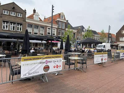 80 Terras aan de noordzijde van de Markt in Steenwijk, afgezet met hekken en met de tafels op ruime afstand van elkaar. ...