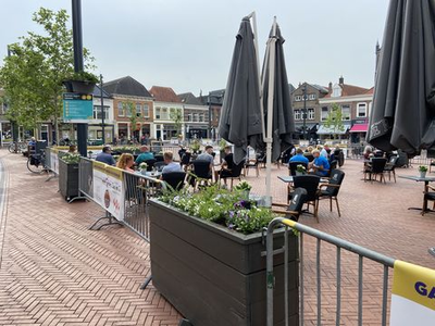 83 Terras aan de oostzijde van de Markt in Steenwijk, afgezet met hekken en met de tafels op ruime afstand van elkaar.