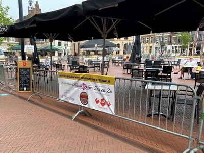 84 De uitgang van het terras aan de noordzijde van de Markt in Steenwijk, afgezet met hekken en met de tafels op ruime ...