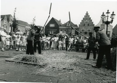 2521 Demonstratie handmatig dorsen op de Markt te Steenwijk