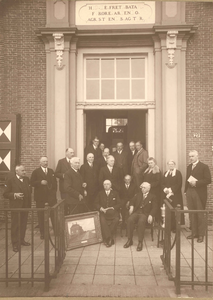  Foto van het bestuur hoogheemraadschap Zeeburg en Diemerdijk bij de deur aan de voorzijde van het Gemeenlandshuis