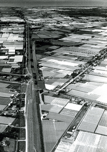 2069 Luchtfoto van de Maasdijk bij de Oranjesluis, gezien richting het westen, z.j. (1980?)