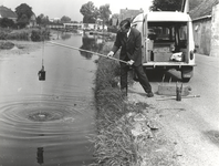 FOTO-000892 Een medewerker van het hoogheemraadschap van Rijnland neemt een watermonster, circa 1965