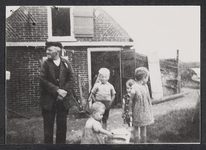 FOTO-700608 Molenaar Arie van der Ploeg staand voor het zomerhuis van de Vlietmolen met kleinkinderen. Hij bemaalde ...