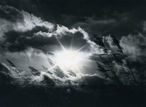 4764 - Evenementen: de Zonnewende - zonopkomst schijnt door een gat in de wolken - op de voorgrond de grashalmen - de ...