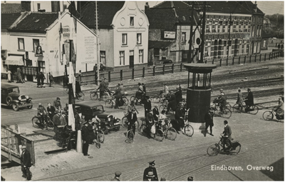 194914 Verkeersoverlast: het oversteken van de Woenselse overweg door fietsers en auto's. Verkeersagenten houden ...