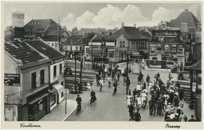 194936 Verkeersdrukte: het oversteken van de Woenselse overweg door fietsers en voetgangers. Linksvoor sigarenhandel De ...