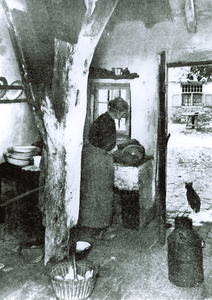 500116 Het schoonmaken in de gootsteen in de keuken in een 17-eeuws Brabants boerderij. Met links een melkbus, 1918