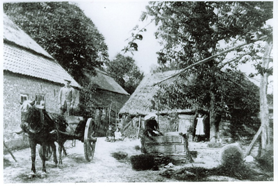 500121 Het putten van water op het erf van een boerderij in Naastenbest, met links de erdkar, 1918