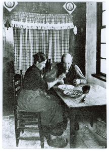 500123 Het eten van een maaltijd in de keuken door Narda en Kees Legius , 1918