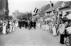 500427 De stoet met Pater Theo Janssen in de Hoofdstraat kort voor het bereiken van de kerk, 15/08/1953