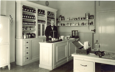 500771 Huisarts Hemricus J.M. Burgering in zijn praktijk annex apotheekruimte, 1950