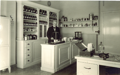 500771 Huisarts Hemricus J.M. Burgering in zijn praktijk annex apotheekruimte, 1950