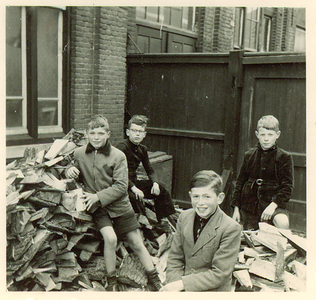 501163 Schooljeugd bij het opruimen van stookhout, 1957