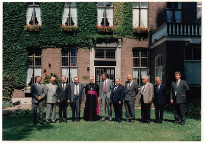 501494 Groepsfoto van Bisschop Mgr. A. Hurkmans met het parochiebestuur van de Sint Odulphusparochie, 05-2001