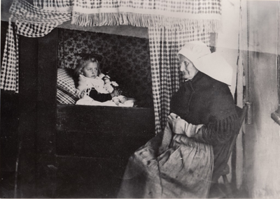 501536 Hanneke Merks - Klompers met een van haar kleinkinderen in de bedstee, 1936