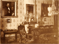 180941 Woonkamer in het huis van de familie Coovels-Bots met aan de muur het portret van Gerardus J. Coovels en rechts ...