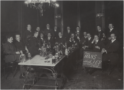 181262 Studenten rond een tafel met bierpullen. Links C. Hoek en Gerard Coovels (staande rechts), z.j.