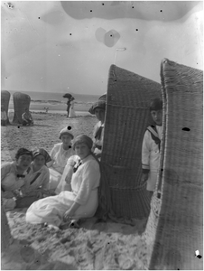 182200 Het zitten in en rond strandstoelen op het strand, 08-1915