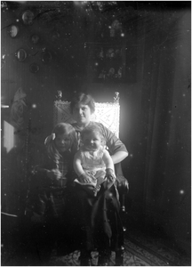 182203 Jo Coovels zit met op haar schoot, Dirk en Louise van Thiel in een stoel, 02-1914