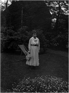 182226 Louise Coovels in de tuin bij een tuinstoel, 1917