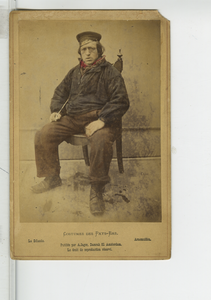 390209 Prentbriefkaart van een visser uit Arnemuiden zittend op een stoel, ca. 1890