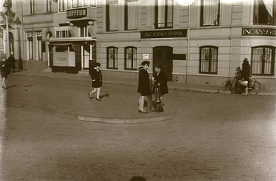 2480 Stationsplein ter hoogte van de Incassobank: het bekijken van een verkeerszuil met olielamp door kinderen, ca. 1930