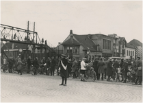 194909 Verkeersdrukte: het regelen van het verkeer bij de Woenselse overweg door verkeersagent Legius, 1935