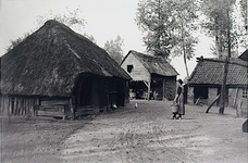 23573 Boerderij in het buitengebied. Boerin loopt met melkemmer over het erf, ca. 1935