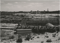 194781 Bouw van de Vestdijktunnel ten behoeve van het nieuwe hoogspoor. Op de achtergrond het nieuwe station in ...