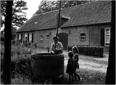 148739 Bets Smulders-Derks haalt water uit de put, haar kinderen Hanny (grootste) en José kijken toe, 09-1966