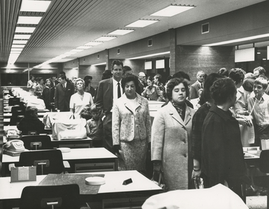 198575 Grote groep belangstellende bezoeken het nieuwe stadhuis, kantoortuin met bureau's, typemachines en telefoons, ...