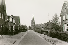 13239 Dorpstraat, gezien richting R.K.-kerk St. Petrus Banden . Met links een kapperszaak, 20-05-1964