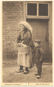 18249 Boerin in klederdracht en met mand en naast haar een kind, 1900 - 1920