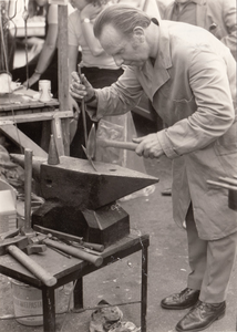 241274 Demonstratie in het smeden van ijzer op een aambeeld door een smid, 1973