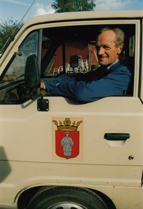 242431 Th. Appeldoorn: Th. Appeldoorn in zijn dienstauto, 19-03-1985