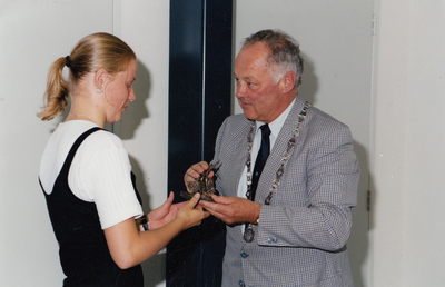 243078 Sonja van Kuik ontvangt uit handen van Burgemeester P. Mangelmans de Dorpsomroeper , 25/07/1995