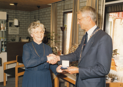 243232 Zuster Gerarda van de Sande ontvangt de gemeentelijke erepenning uit handen van Burgemeester J. de Widt, 30/08/1988