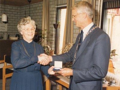 243903 Zuster Gerarda ( H. van den Broek) ontvangt de Gemeentelijke erepenning in zilver uit handen van Burgemeester J. ...