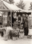 244196 Weekmarkt : het verkopen van bloemen, 1974