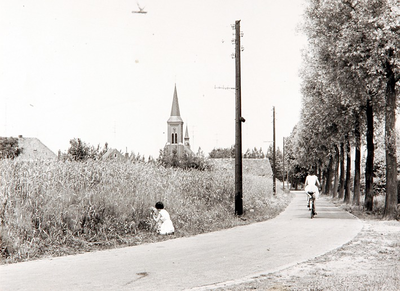 29187 Het plukken van bloemen naast een korenveld, met op de achtergrond de RK-kerk St.Antonius Abt, 1963