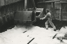 195722 Medewerker richt de schep van de hijskraan om zout te scheppen, 1979