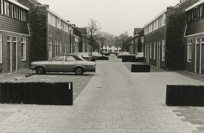 195968 Opgeknapte huizen, geparkeerde auto's en plantenbakken gemaakt van bielzen, 1978